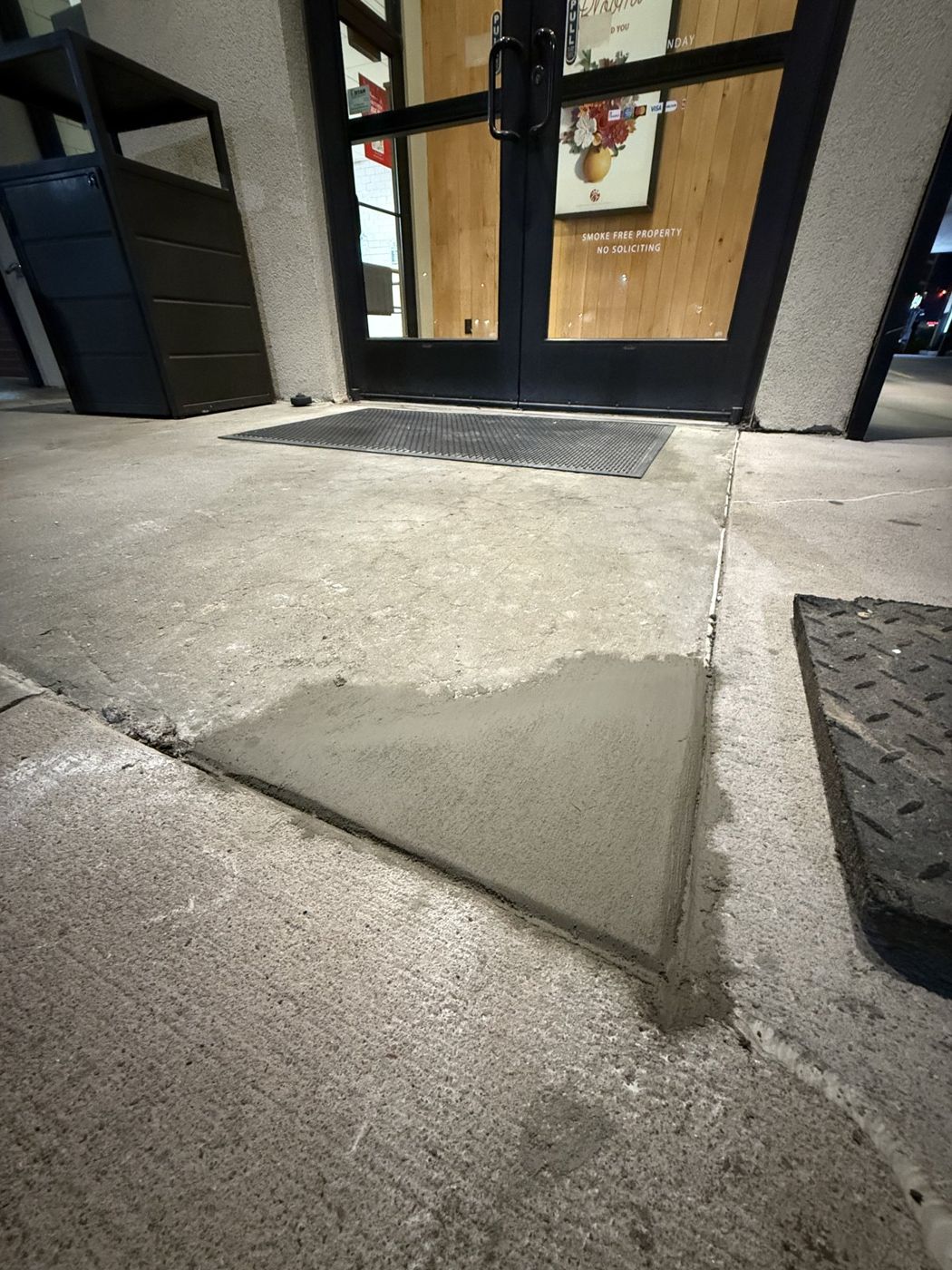 Concrete sidewalk patch at a building entrance in the Omaha area