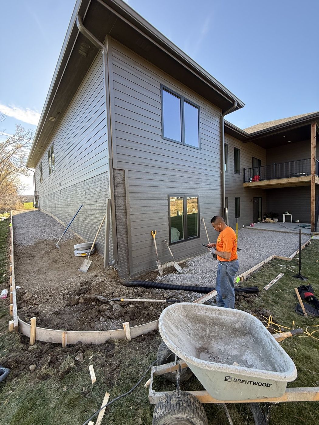 Forming a new concrete sidewalk alongside an apartment building near Omaha