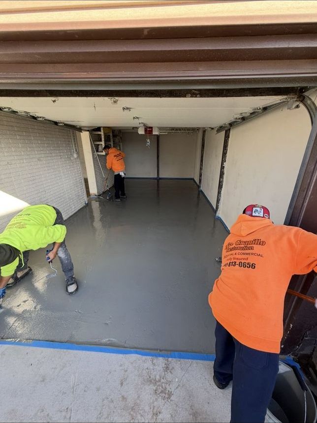 Elite Granillo Restoration crew applying a garage floor coating near Omaha